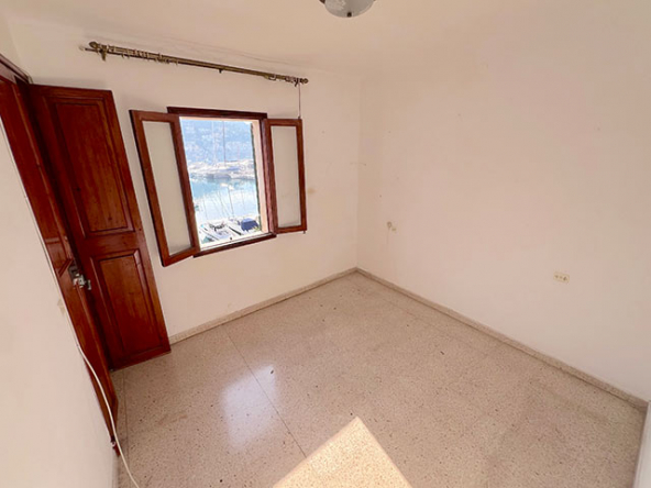 Dormitorio principal con luz natural y vistas laterales al puerto