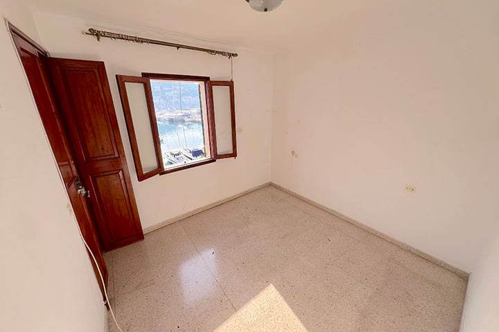 Dormitorio principal con luz natural y vistas laterales al puerto